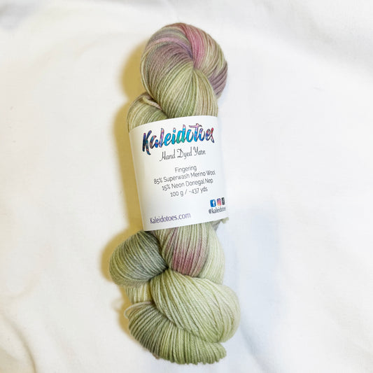 Hand-dyed skein of yarn in soft orchid pink and tonal sage greens, inspired by a blooming cactus flower in the desert.