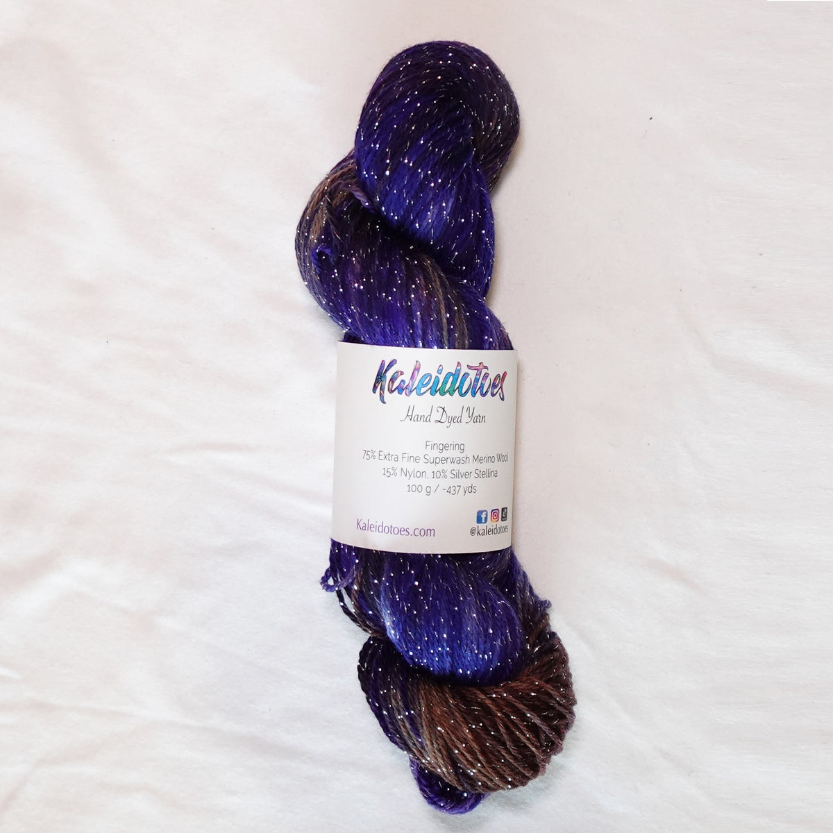 Decadent Behavior hand-dyed fingering weight yarn in saturated violet and deep chocolate brown with rich plum tones and a fine silver metallic thread.