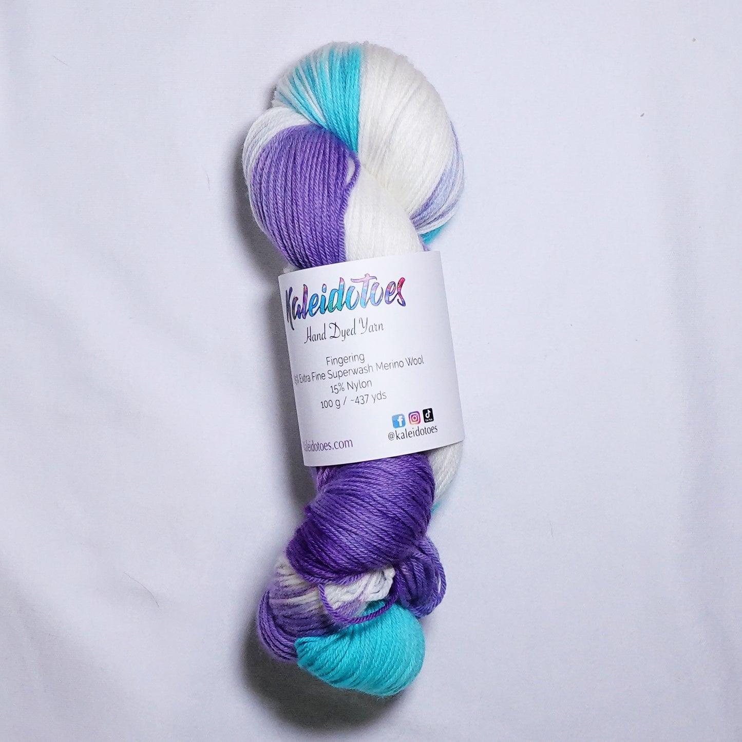 Hand dyed fingering weight sock yarn in bright aqua, hyacinth purple, and white, hand dyed by Kaleidotoes in Las Vegas