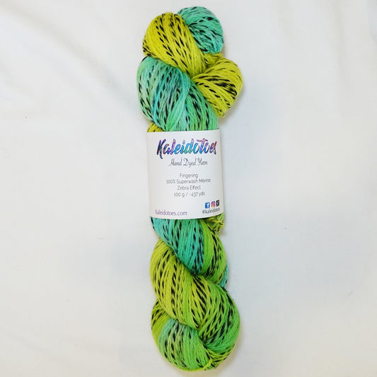 Hand-dyed fingering weight yarn in electric chartreuse, lime, and light emerald with black twisted through throughout.