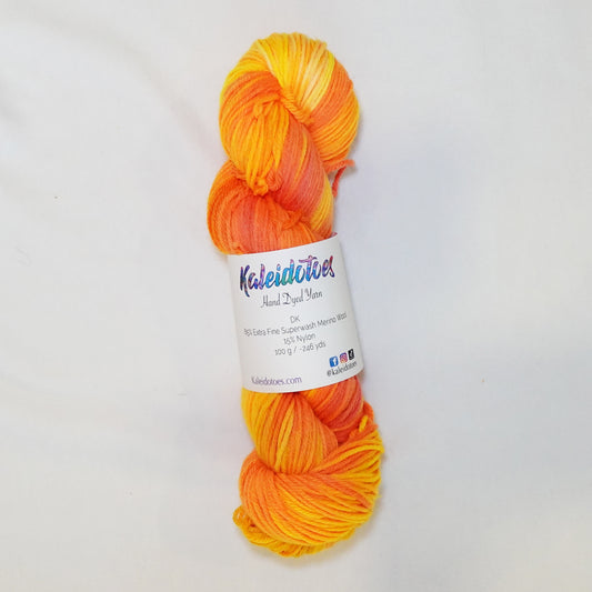 Hand-dyed DK weight yarn in golden yellow, tangerine, and blazing orange - vivid, saturated, and unapologetically bright.