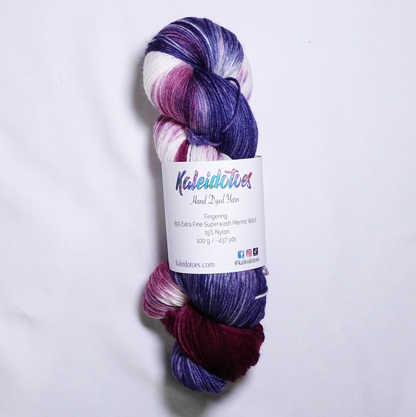 Hand dyed fingering weight sock yarn in deep cabernet red, navy blue, and white, hand dyed by Kaleidotoes in Las Vegas