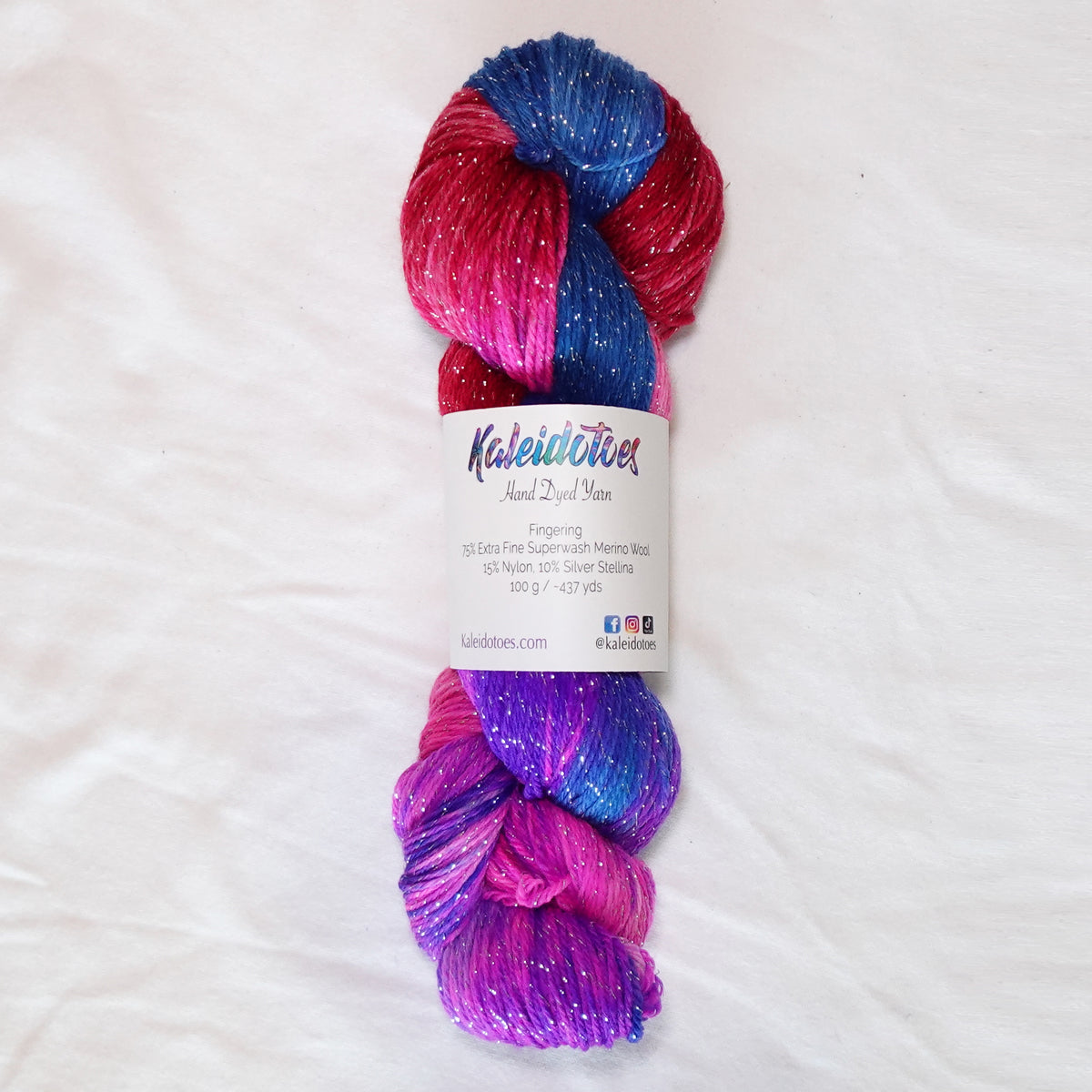 No Curfew hand-dyed fingering weight yarn in brilliant blue, purple, hot pink and red with a fine silver metallic thread.