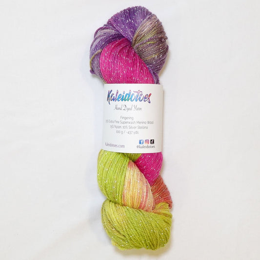 Hand-dyed fingering weight yarn in chartreuse, coral, hot pink, magenta, and violet with silver metallic thread and scattered white patches throughout.