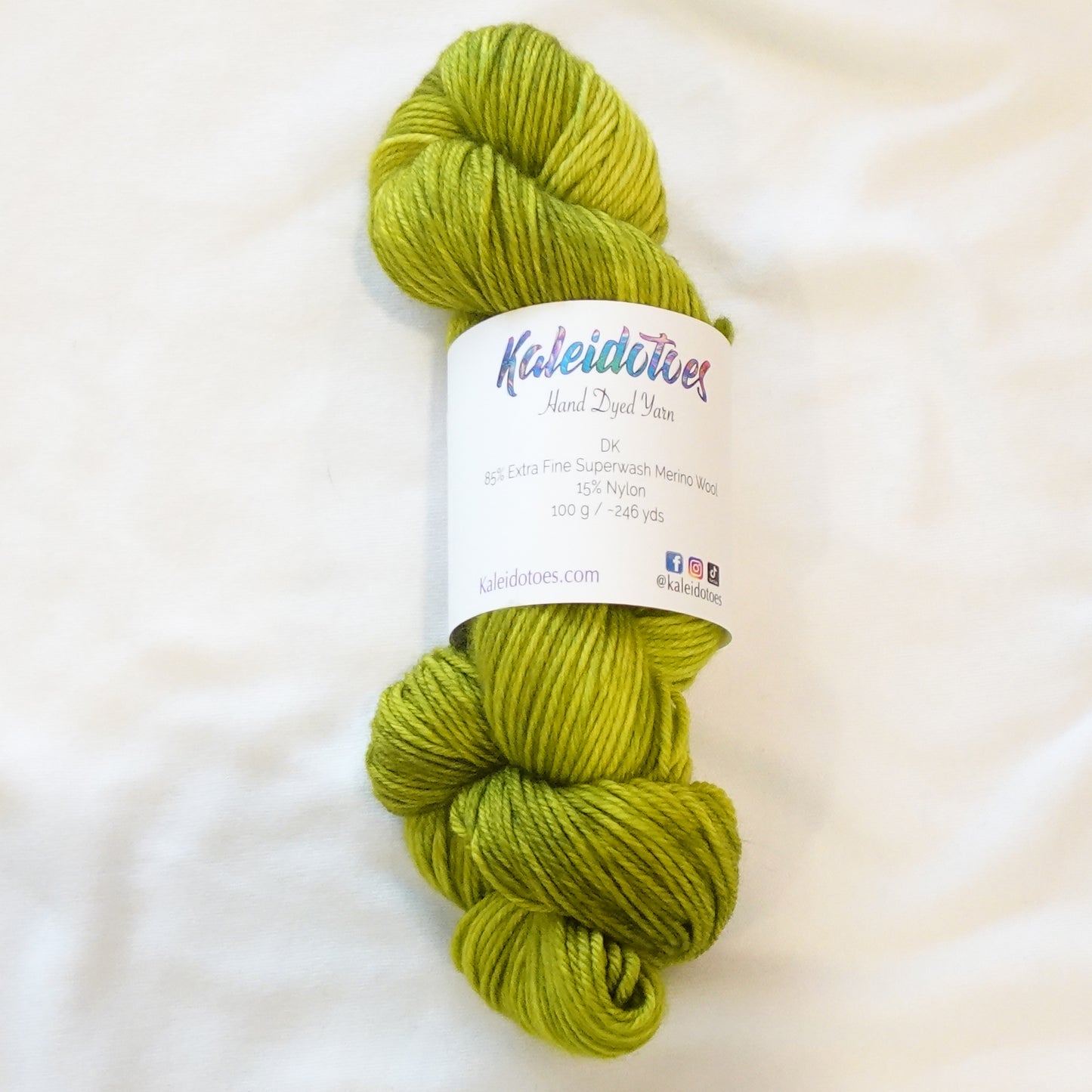 Hand-dyed yarn in vivid peridot green with subtle golden-yellow undertones and bright jewel clarity, inspired by Ra, the Egyptian sun god.