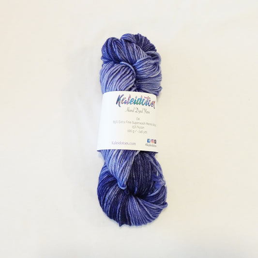 Hand-dyed yarn skein in layered blue tones with variegated depth ranging from light to deep shades