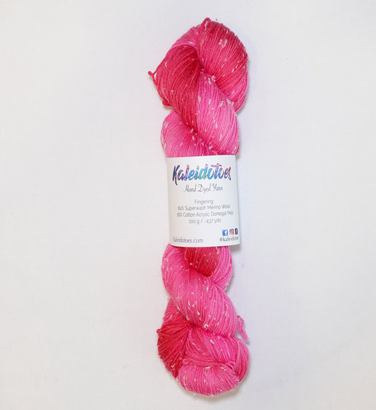 Hand-dyed yarn in vibrant pink and berry red tones with soft white flecks — bright, juicy, and playful.