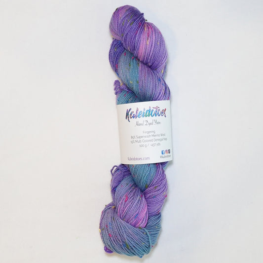 Hand-dyed yarn in violet and blue tones with colorful flecks — vibrant, dynamic, and reminiscent of confetti in a night sky.
