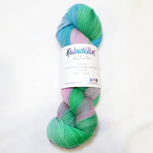 Hand-dyed yarn in soft aqua, sky blue, fresh green, and orchid pink tones — flowing and blended like watercolor in motion.