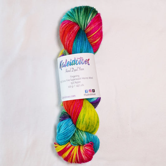 Hand-dyed fingering weight yarn with hot pink, turquoise blue, vivid yellow, green, orange, and purple in a bright multicolor variegated colorway.