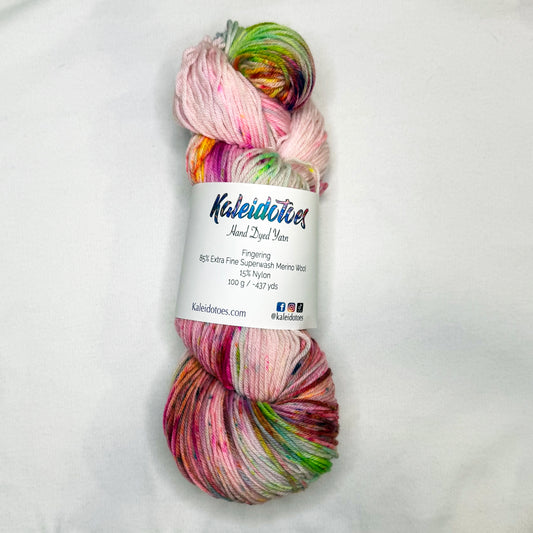 Hand-dyed yarn in soft cream with bright speckles of pink, lime, and magenta — playful, floral, and full of spring sparkle.