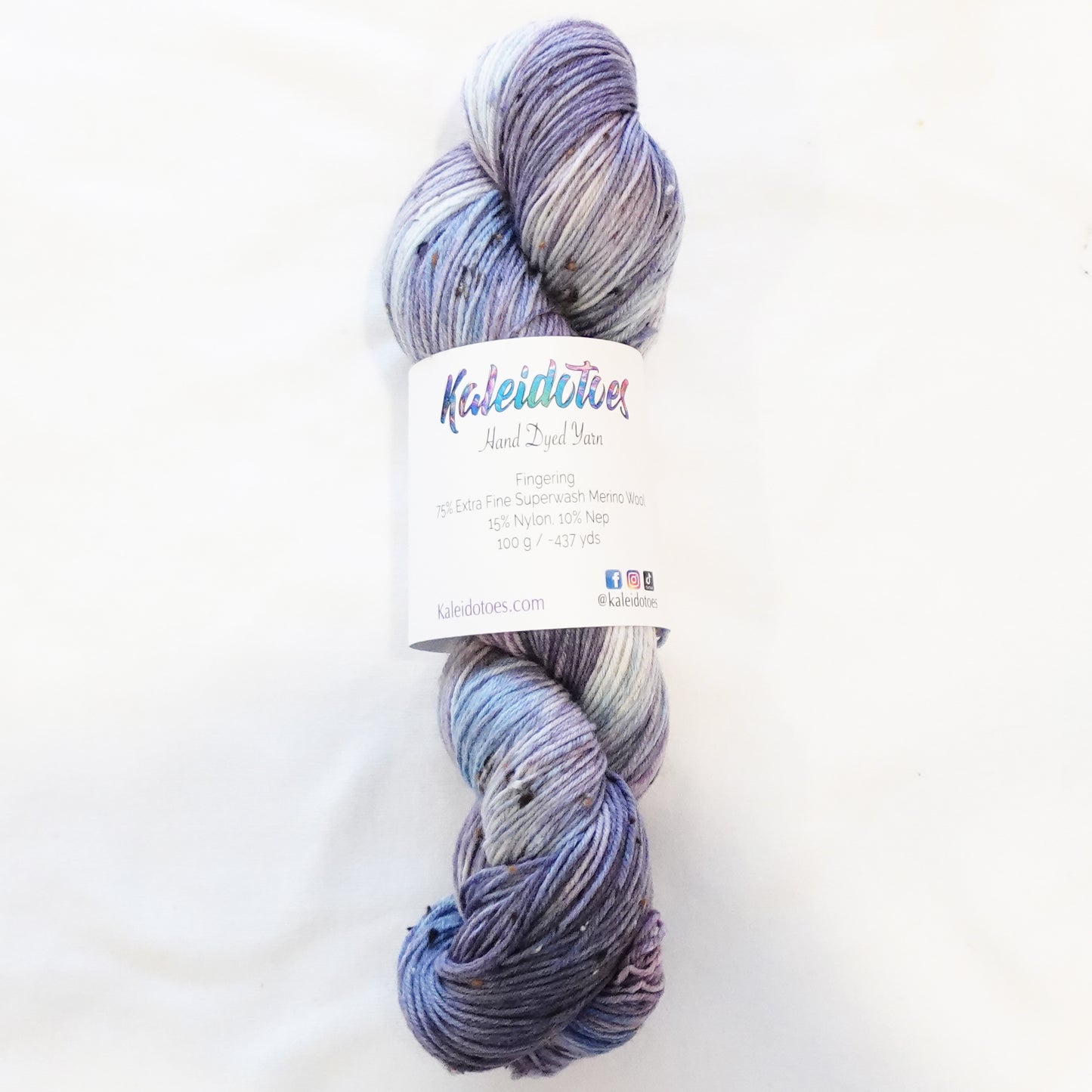Hand-dyed tweed yarn in dusty mauve and soft grey-blue — muted, atmospheric, and quietly complex with subtle flecks throughout.