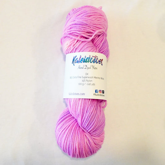 Hand-dyed yarn skein in layered cool pink tones ranging from pale blush to deeper petal pink