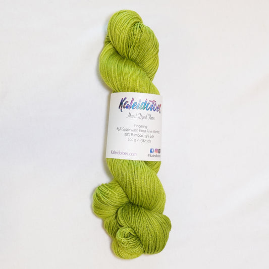 Hand-dyed fingering weight yarn in tonal electric chartreuse green.