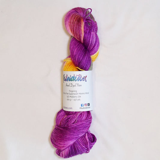Hand-dyed fingering weight yarn in saturated purple, magenta, hot pink, golden yellow, and muted cactus green.