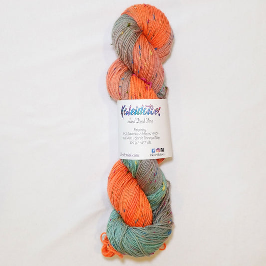 Hand-dyed fingering weight yarn in coral, seafoam, and blush with multicolor confetti flecks throughout.