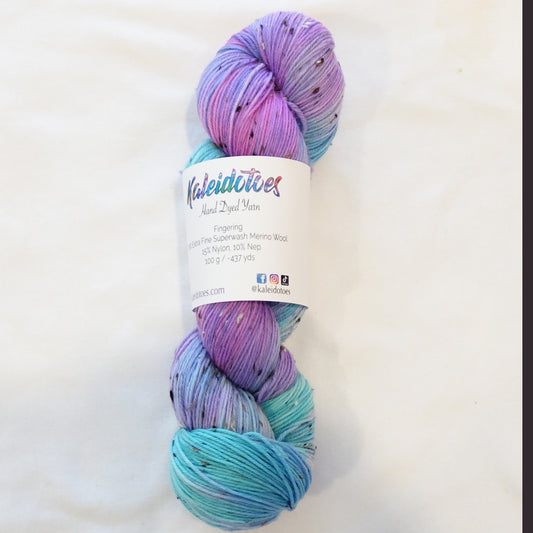 Hand-dyed tweed yarn in soft pink, periwinkle, and pale lavender tones with subtle flecks — dreamy, airy, and softly layered.