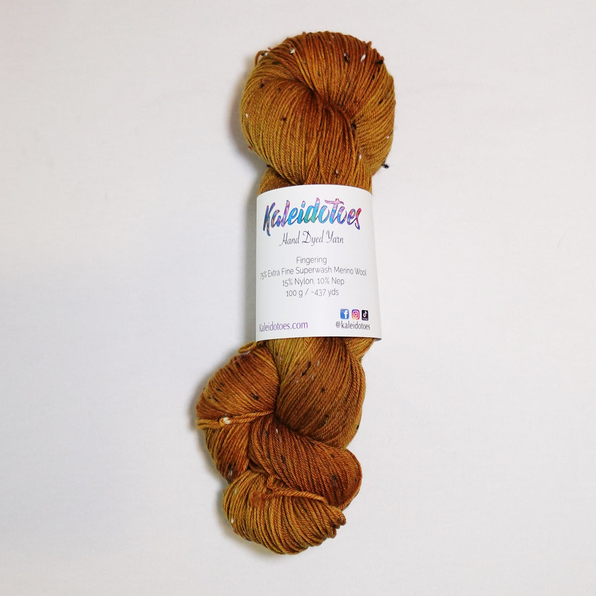 Hand-dyed tweed fingering weight yarn in whiskey gold, aged amber, caramel and toasted brown with tweed flecks.