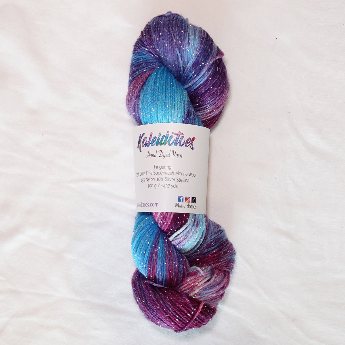Hand-dyed silver metallic fingering weight yarn in icy blue, rich berry purple and amethyst with a fine silver metallic thread.