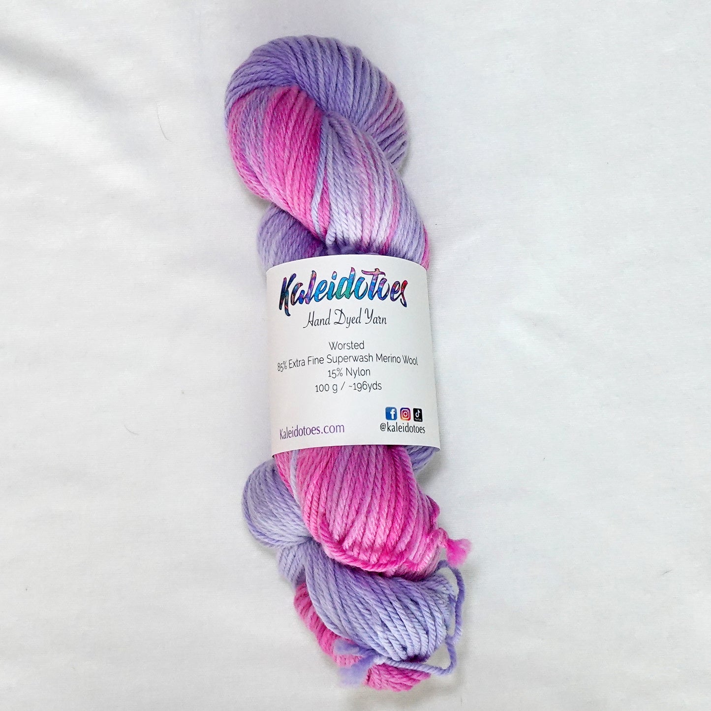 Hand-dyed worsted weight yarn in deep pink, blush, lilac, and soft lavender with smooth gradient transitions throughout.