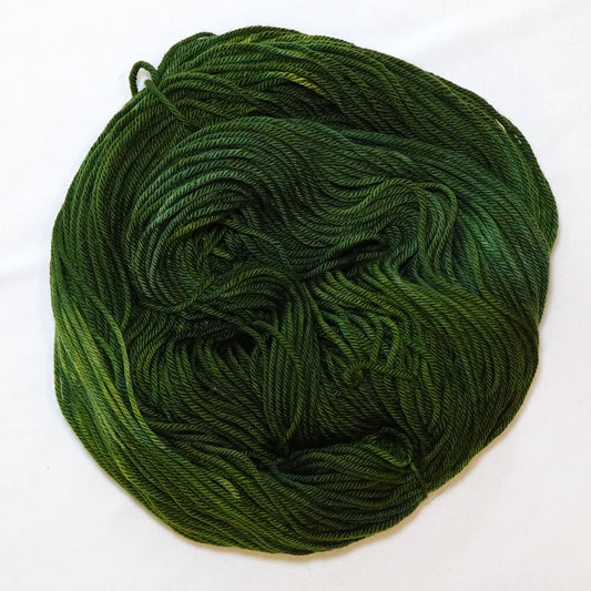 Hand-dyed worsted weight yarn in deep hunter green and olive tones with occasional lighter green variation.