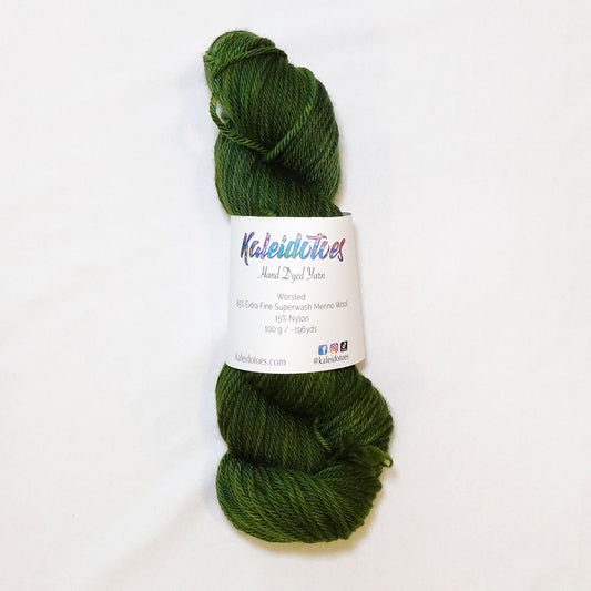 Hand-dyed worsted weight yarn in deep hunter green and olive tones with occasional lighter green variation.
