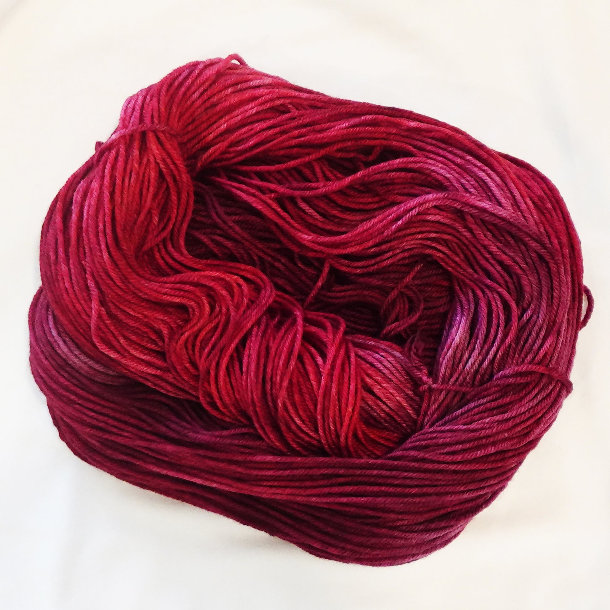 Hand-dyed yarn in deep garnet red tonal shades with rich wine undertones and dramatic jewel-like depth, inspired by Egyptian royalty and ancient dynasties.