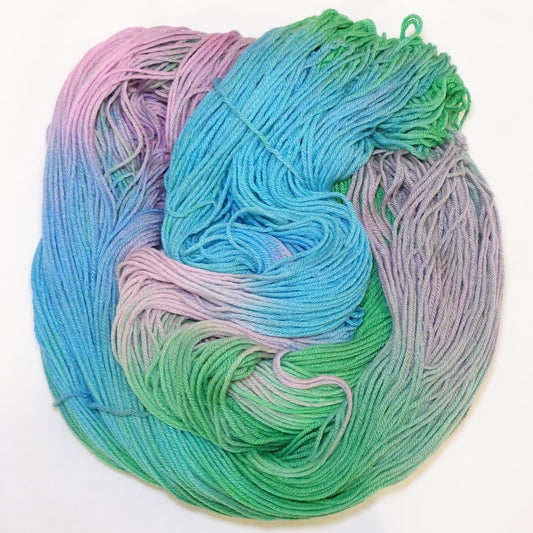 Hand-dyed yarn in soft aqua, sky blue, fresh green, and orchid pink tones — flowing and blended like watercolor in motion.
