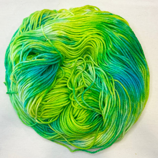 Hand-dyed yarn in vivid lime and teal hues — bright, lush, and glowing like a tropical garden at sunrise.