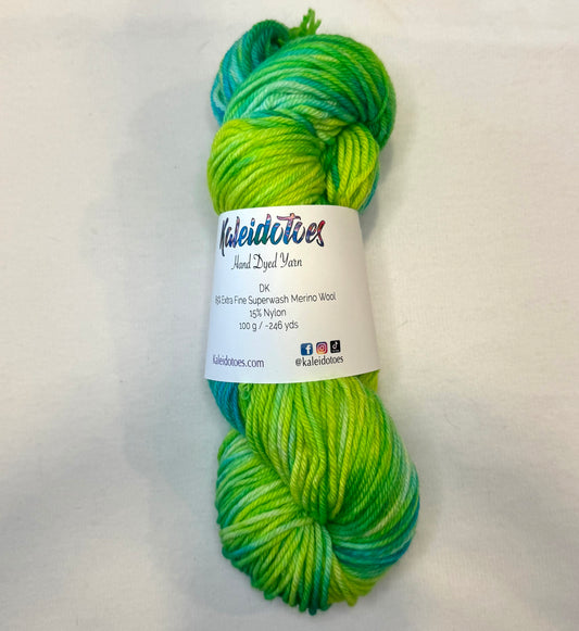 Hand-dyed yarn in vivid lime and teal hues — bright, lush, and glowing like a tropical garden at sunrise.