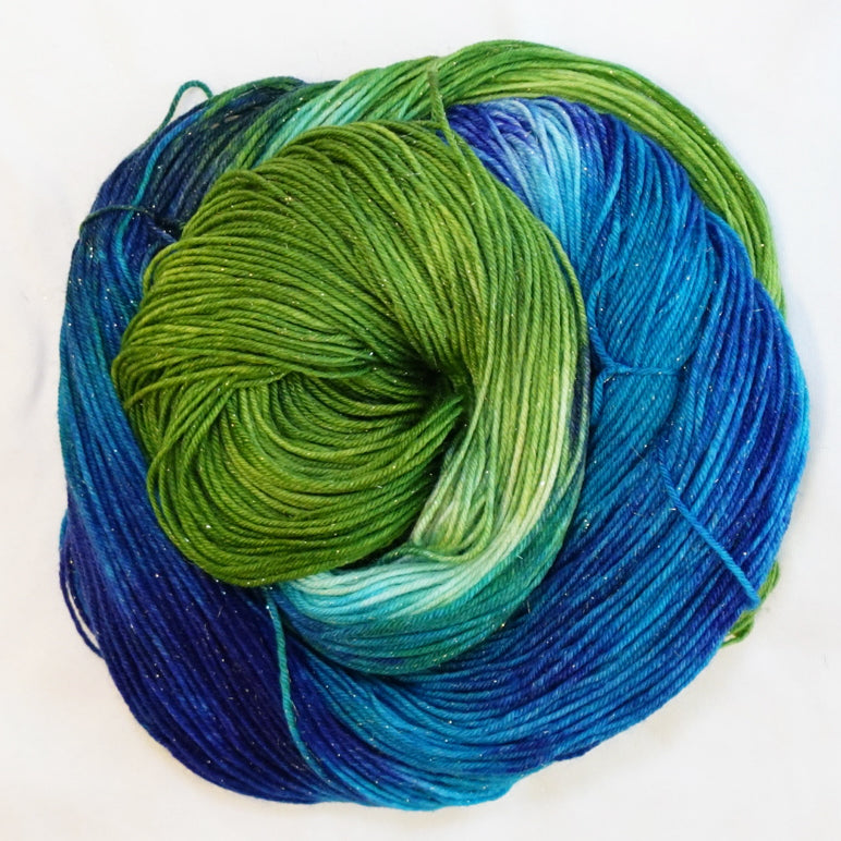 Hand-dyed gold metallic fingering weight yarn in deep blue, turquoise, sea-glass aqua and lush green with a fine gold metallic thread.