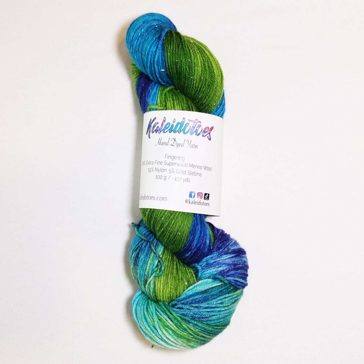 Hand-dyed gold metallic fingering weight yarn in deep blue, turquoise, sea-glass aqua and lush green with a fine gold metallic thread.