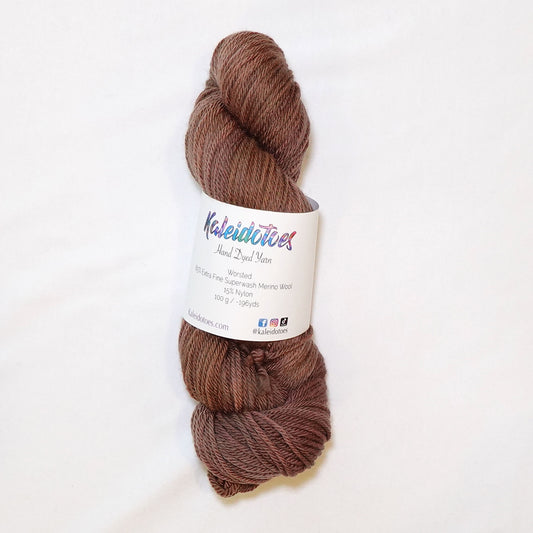 Hand-dyed worsted weight yarn in warm faded chestnut brown tones with gentle sun-softened tonal variation throughout.