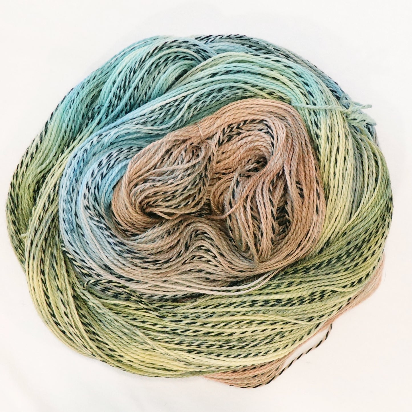 Hand-dyed fingering weight yarn in sand, sage, sky blue, and olive with black threading throughout on a zebra base.