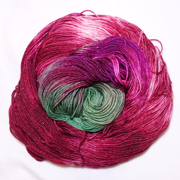 Hand-dyed gold metallic fingering weight yarn in rich crimson, deep berry and leafy green with a fine gold metallic thread.