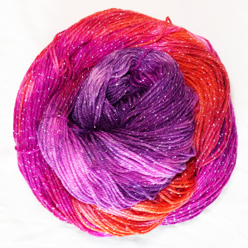 House Sangria hand-dyed fingering weight yarn in rich wine purple, berry pink and red-orange with a fine silver metallic thread.