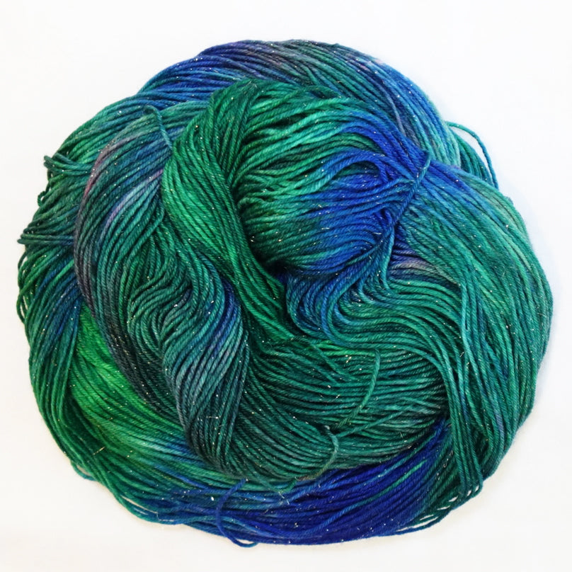 Hand-dyed gold metallic fingering weight yarn in brilliant emerald, deep teal and vivid blue with a fine gold metallic thread.