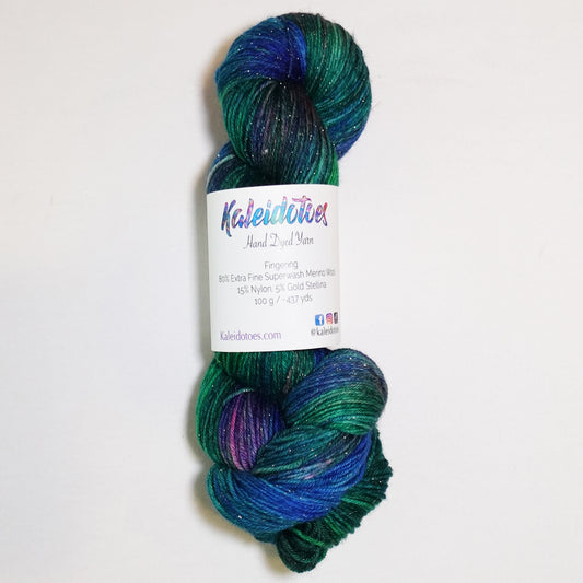 Hand-dyed gold metallic fingering weight yarn in brilliant emerald, deep teal and vivid blue with a fine gold metallic thread.