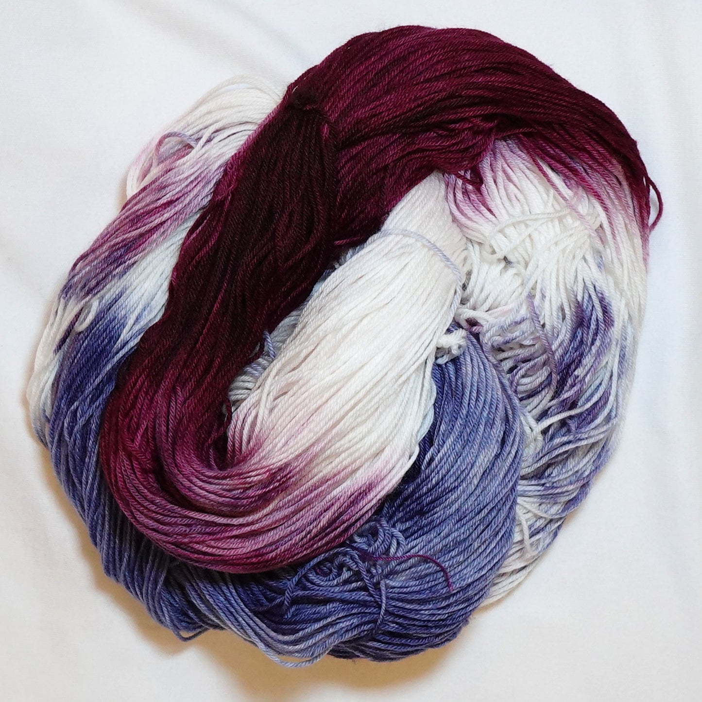  Hand dyed fingering weight sock yarn in deep cabernet red, navy blue, and white, hand dyed by Kaleidotoes in Las Vegas