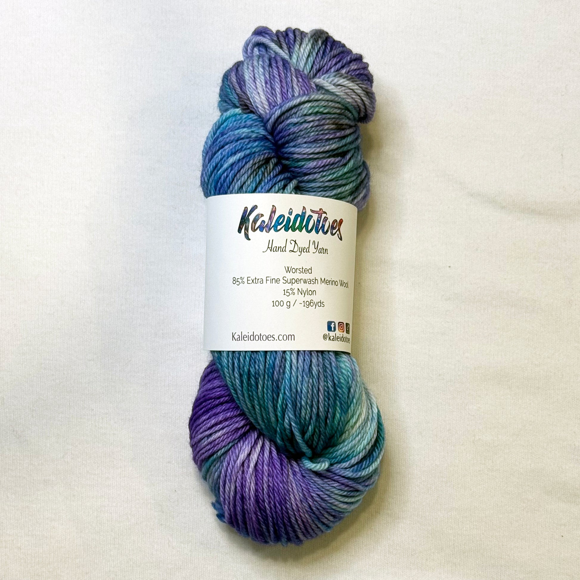 Hand-dyed yarn in teal, blue, and violet tones with touches of black, inspired by icy glacial colors.