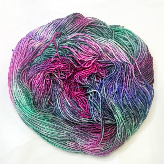 Hand-dyed yarn in deep violet, teal, mint, and soft white — moody, elegant, and softly luminous.