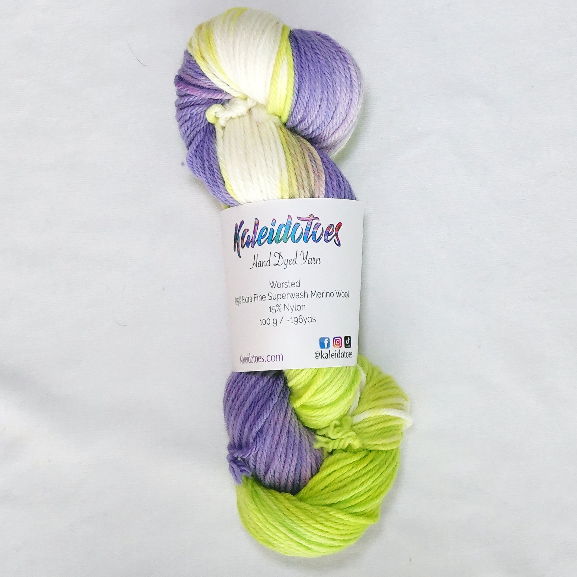 Hand-dyed worsted weight yarn in electric chartreuse, creamy white, and soft lavender.