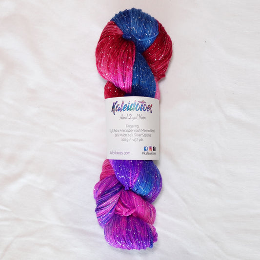 No Curfew hand-dyed fingering weight yarn in brilliant blue, purple, hot pink and red with a fine silver metallic thread.