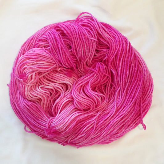 Hand-dyed yarn in vibrant pink tourmaline tones with saturated jewel depth and radiant tonal variation, inspired by the Egyptian goddess Isis.