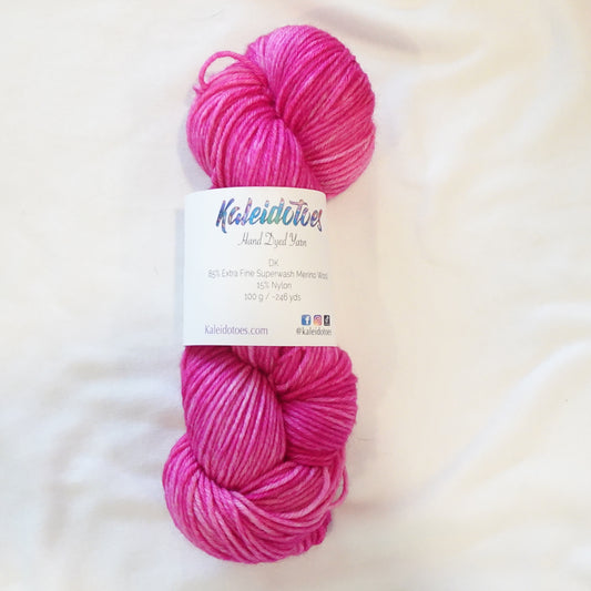 Hand-dyed yarn in vibrant pink tourmaline tones with saturated jewel depth and radiant tonal variation, inspired by the Egyptian goddess Isis.