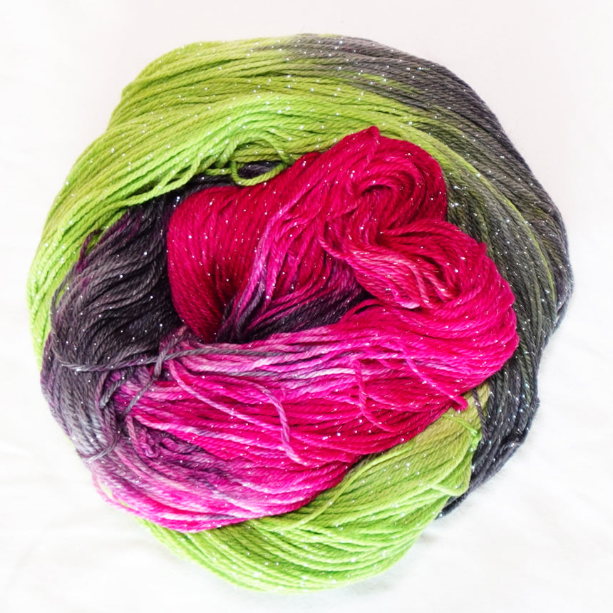 Practically Magic hand-dyed fingering weight yarn in brilliant fuchsia, vivid green and smoky charcoal with a fine silver metallic thread.