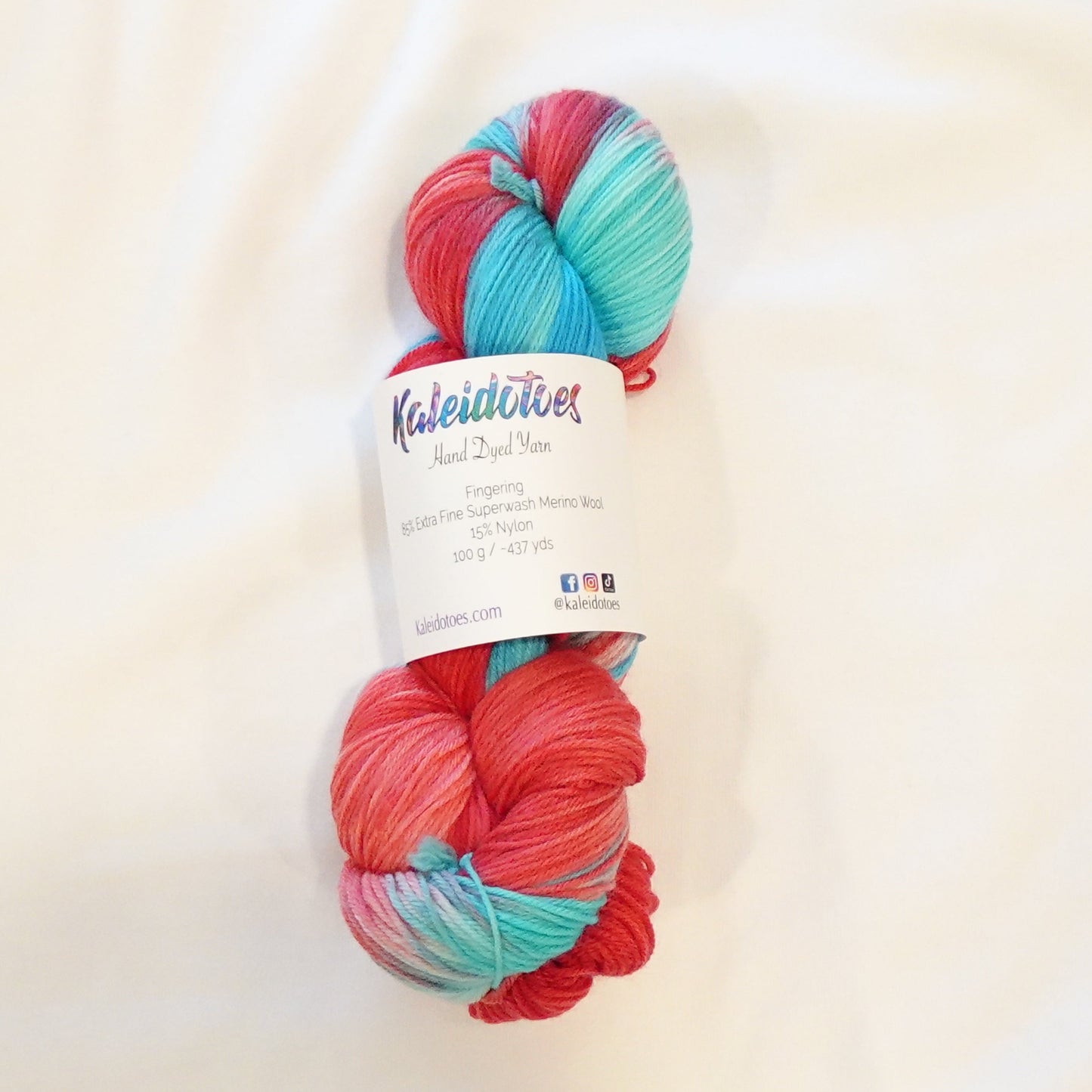 Hand-dyed yarn in bright red, aqua blue, and soft white tones — bold and refreshing like a classic rocket pop popsicle.