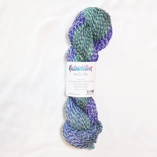 Hand-dyed fingering weight yarn in sea glass teal, misty aqua, and royal blue with white twisting through.