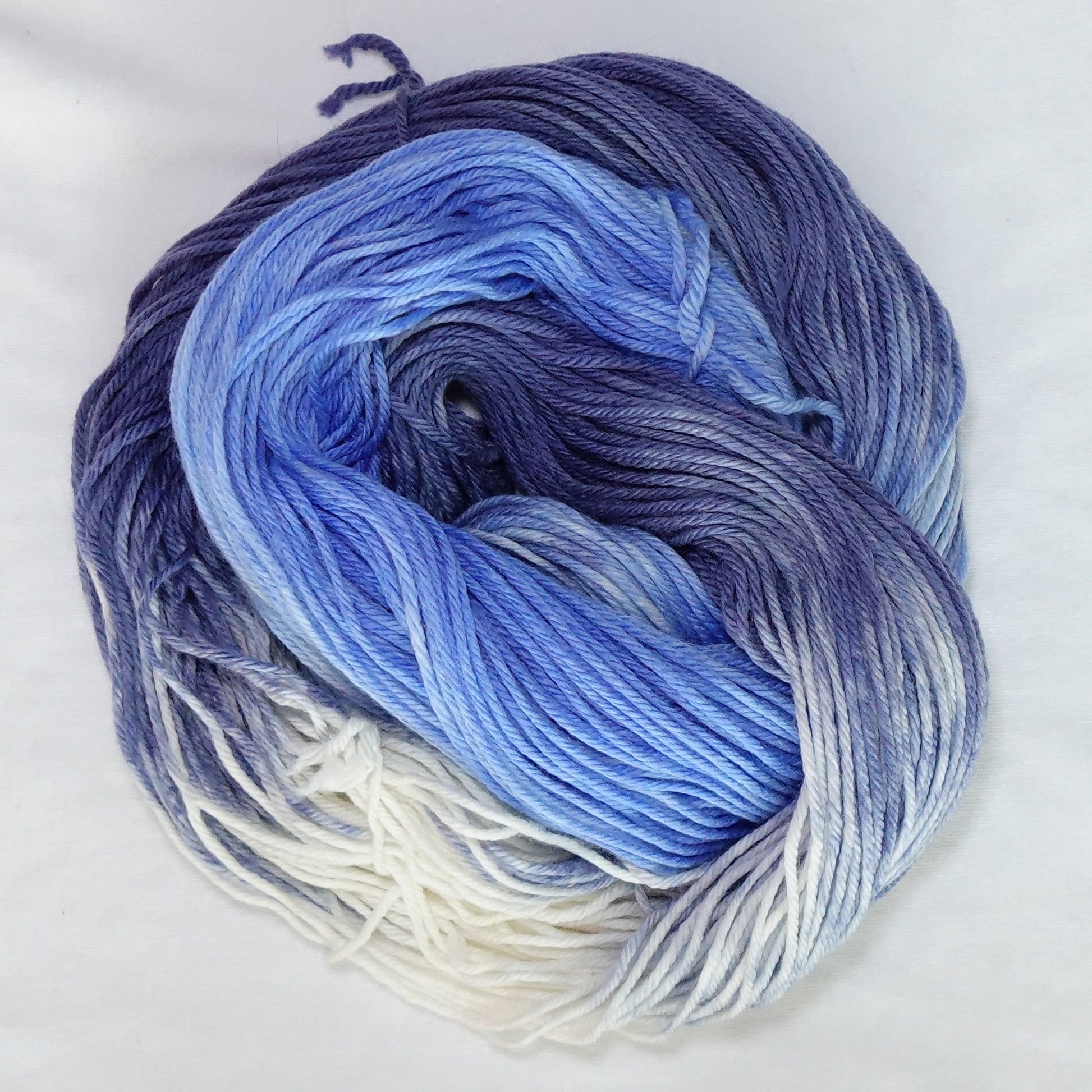 Hand-dyed worsted weight yarn in white, cornflower blue, periwinkle, and deep indigo with a clean gradient transition throughout.