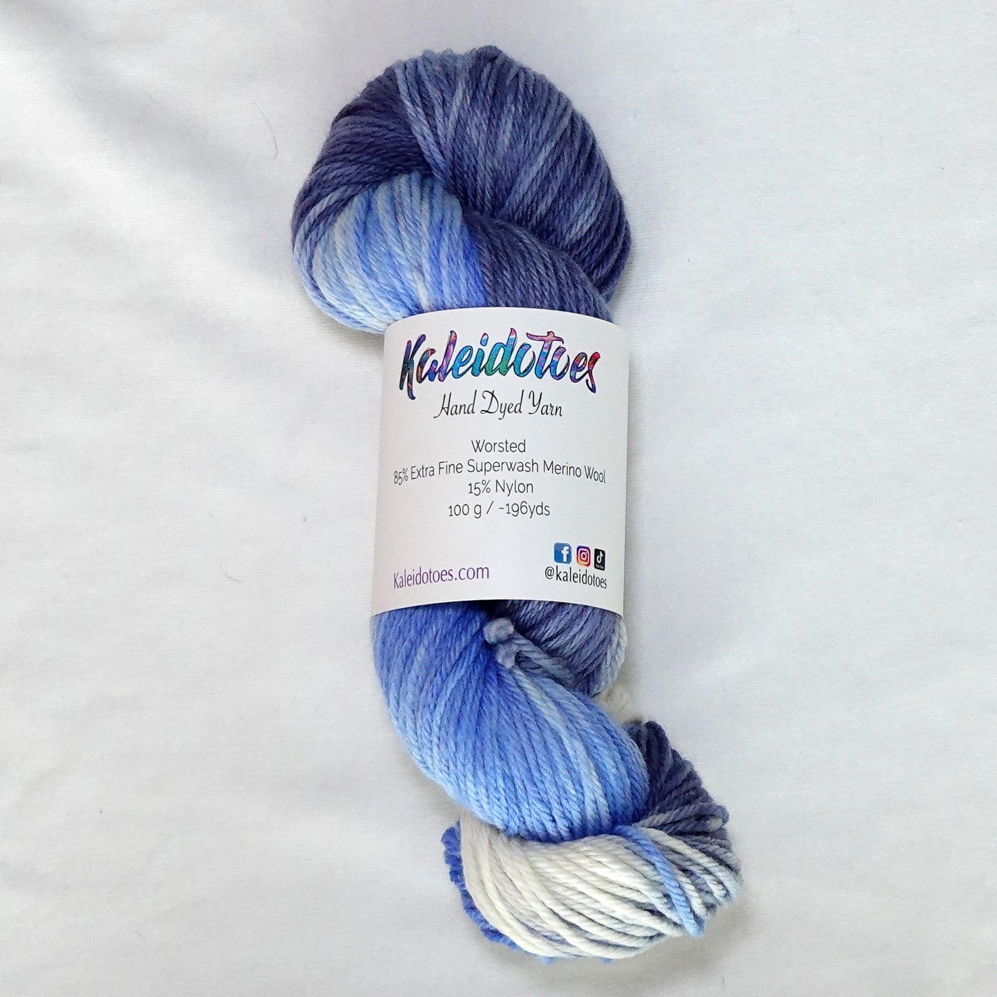 Hand-dyed worsted weight yarn in white, cornflower blue, periwinkle, and deep indigo with a clean gradient transition throughout.